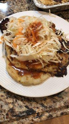 Pupusa stuffed with chicharrón with curtido and tomato sauce on top