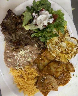 Chilaquiles served with Carme asada, two eggs, rice, beans, salad and corn tortillas