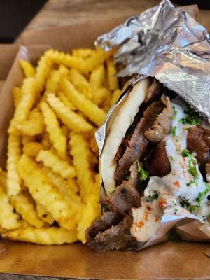 Lamb gyro with a side of crinkle fries.