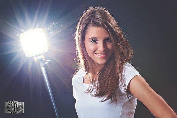 Senior Portrait with a senior in front of a light stand.