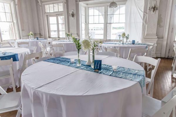 The historic ballroom prepped for a summer wedding with white linen & a flood of natural light