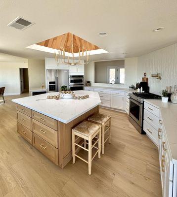 Finished work. Kitchen installation oak shaker cabinets on island and white shaker with quartz countertops