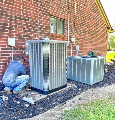 Colley's professional technician doing a Ac service on a unit outside