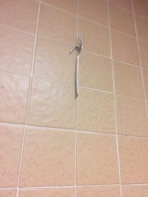 Fork hanging on the wall by a nail