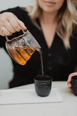 6 rotating flavors of tea served in a glass carafe with custom handmade tea cups