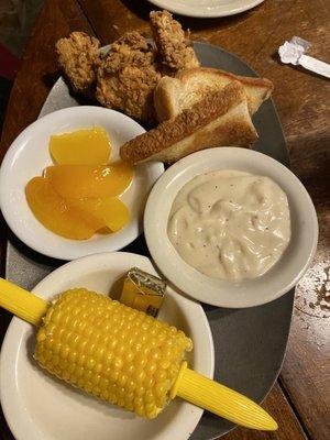 Kids chicken strips with corn on the cob and peaches. Also came with toast and gravy.