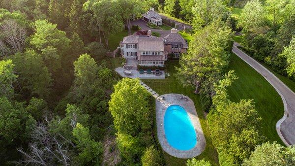 Drone photo showcasing the back view of the property highlighting all the features including the pool.