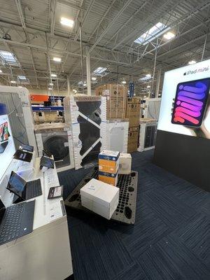 Randomly placed boxes of printers and home appliances in the Apple/Microsoft Tablet section.