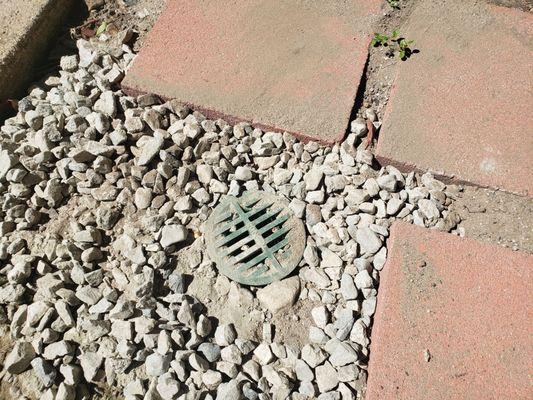 Drain surrounded by gravel now, the heavy rains eroded all the dirt around it