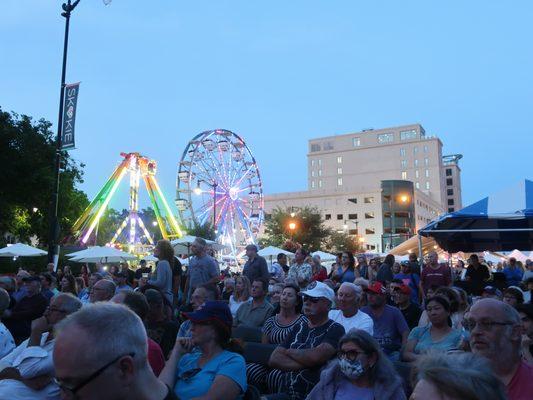 From the main stage audience, a view at dusk towards the rides.