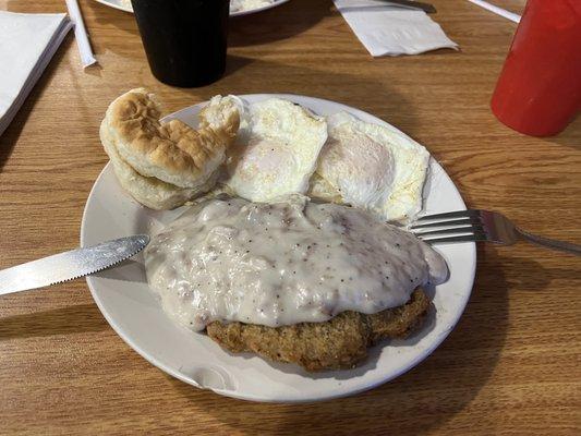 Country fried steak with gravy eggs and biscuit