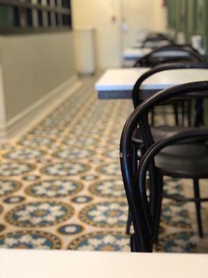 Pretty tile floors and small white tables for 2 only.