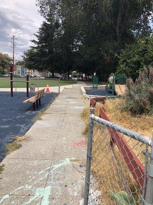 Walk way. Swings, grassy fields beyond