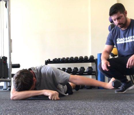 Pictured here is Head Coach Derek coaching Jason through a shoulder exercise.  Jason's goal is to increase his swing speed.