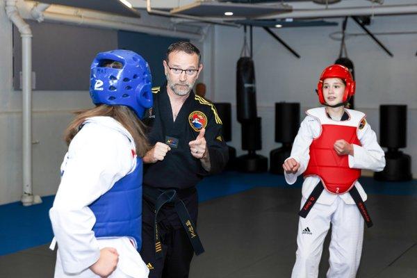 Master Uptergrove coaches two students during a sparring match.