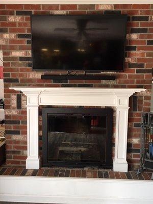 Fabricating a new mantle and hanging a TV helps bring this brick wall up to date