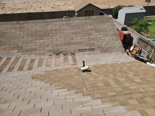 Wind damaged shingle roof with missing granuals and mismatched color