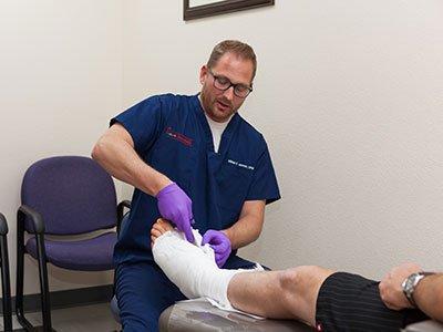 Dr. Mikkel Jarman cutting off a cast at Preferred Foot & Ankle Specialists.