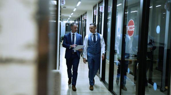 The partners of Fisher Stone walking through the halls discussing business law and real estate law.