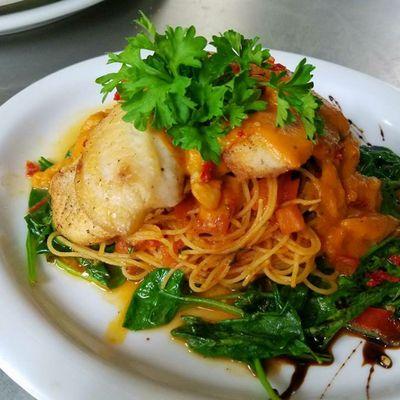 Tillapia on a bed of fresh spinach and angel hair pasta marinara