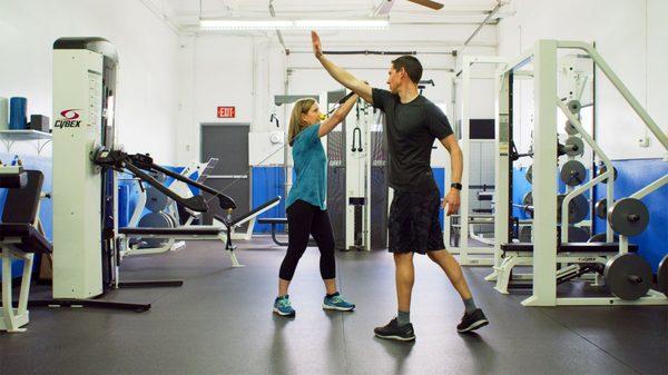 George shows a client proper form with a functional trainer exercise.