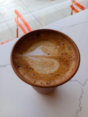 Personal unglazed naked mug beholds my oat house decaf latte.