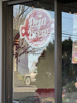 The "Deja Brew" storefront window sign