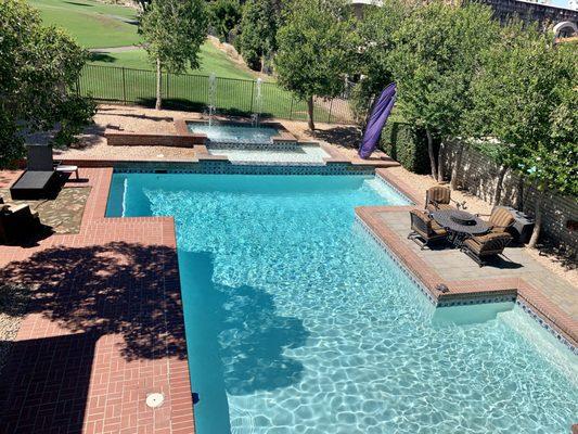 Very large pool surrounded by trees with fountains and a big spa too!