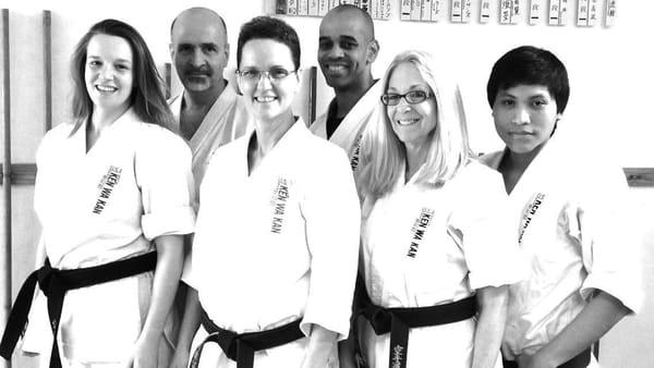 Shihan stands in the middle surrounded by her instructors for children and adult classes.