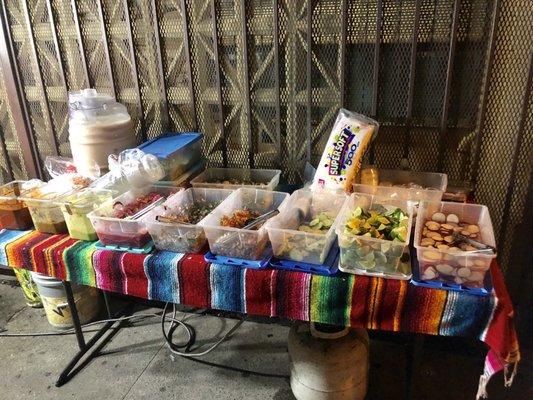 All the fixings various salsas, onions, cilantro, radish, lemons, nopales, and even frijoles de la olla.