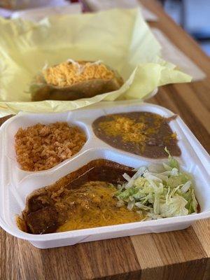 My meal with cheese enchilada, beans and rice. The chicken taco is on yellow paper.