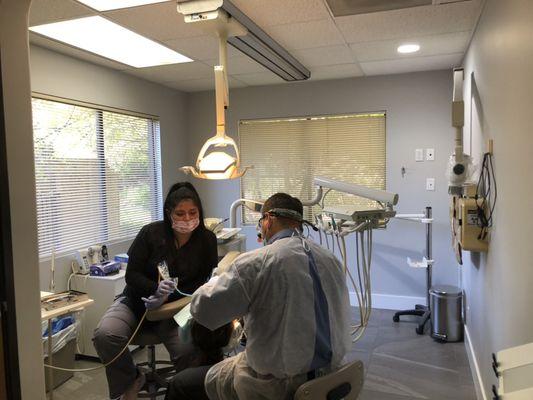 Dr. Urdaneta and his dental assistant treating a patient