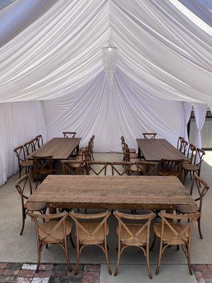 Draped tent, farm tables and cross back chairs