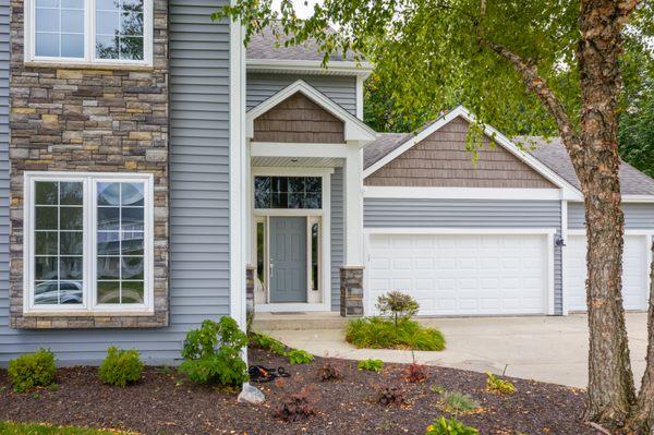 Modern columns with Versetta stone bases, bold trim & accented gables gave this home a contemporary look and great curb appeal.