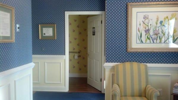 Designer blue wall covering, chair rail and traditional shadow boxes installed in this clients foyer.