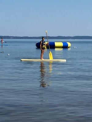 Paddle board with trampoline in background