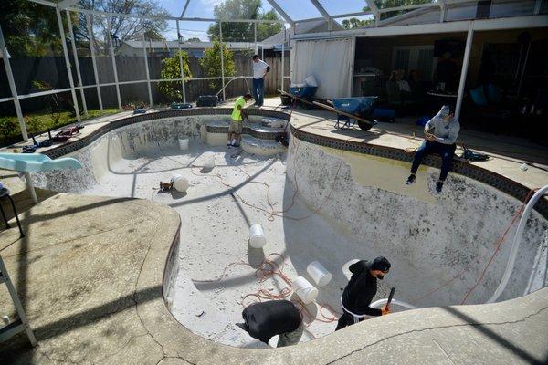 Chipping out the inside of a pool so the pool interior can be resurfaced