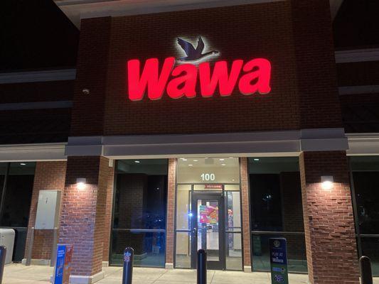 Wawa sign at night, the back door is not as busy