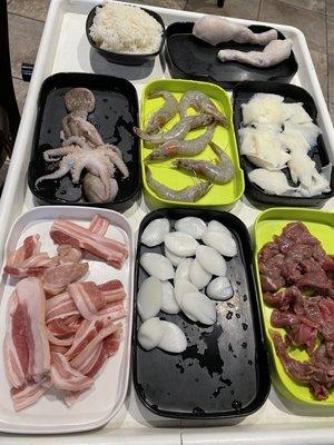 White rice, octopus, pork belly, shrimp, ox throat, frog legs, scallops, marinated beef  (From top left down)