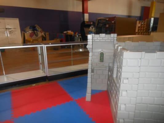 Glass display cases being used as "Barriers" between the castle/slide play area and where they store unused equipment.