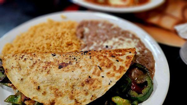 Dinner Quesadilla (chicken, steak, shrimp) cooked with onions, peppers, tomatoes and Chipotle sauce. Served with rice and beans