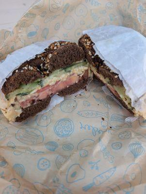 Egg salad sandwich on pumpernickel everything bagel