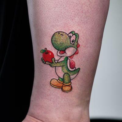 Glitter Yoshi tattoo holding an apple on my outer calf