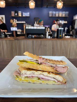 Cuban sandwich with ham, roasted pork, Swiss cheese, yellow mustard and dill pickles.