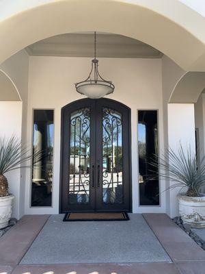 Custom pair of Ornamental Iron Entry doors with Hinged Grills to access/ clean glass easily. Clear LOW E glass.