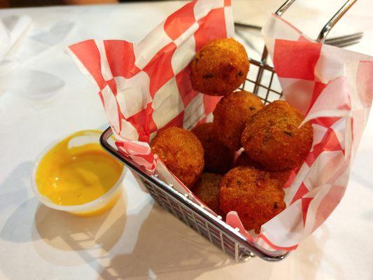 Hot, sweet and crispy hush puppies with side of honey mustard sauce