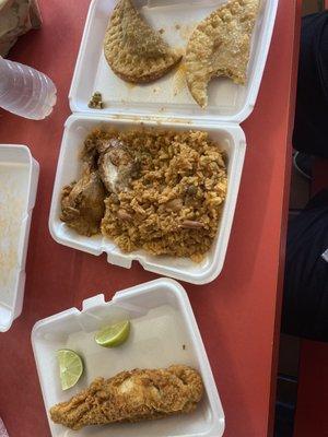 Yellow rice with stew chicken, fried fish, and chicken empanadas