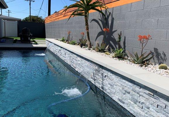 Spillways creating a blissful soundscape in this pool and spa we built. Planters, swimming pool builders in Southern California