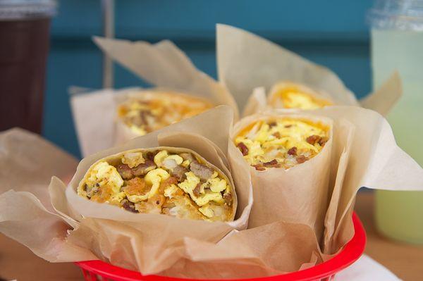 Breakfast burritos; Large flour tortilla with 3 scrambled eggs, choice of tater tots or potatoes, add chorizo,  bacon,  or sausage + $2.75