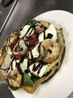 Fresh greens in a pita bread bowl basket topped with chargrilled shrimp , fresh mozzarella and balsamic dressing